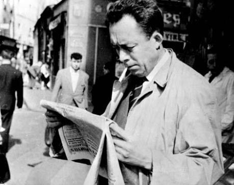 Albert Camus reading a newspaper